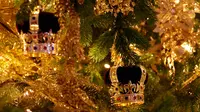 Replika mahkota dipasang pada pohon cemara besar dari Windsor Great Park di ujung aula St. George di Windsor Castle, 30 November 2018. Pohon setinggi 6 meter itu dihias dengan pernak-pernik Natal berwarna emas serta ornamen kerajaan.  (AP/Frank Augstein)