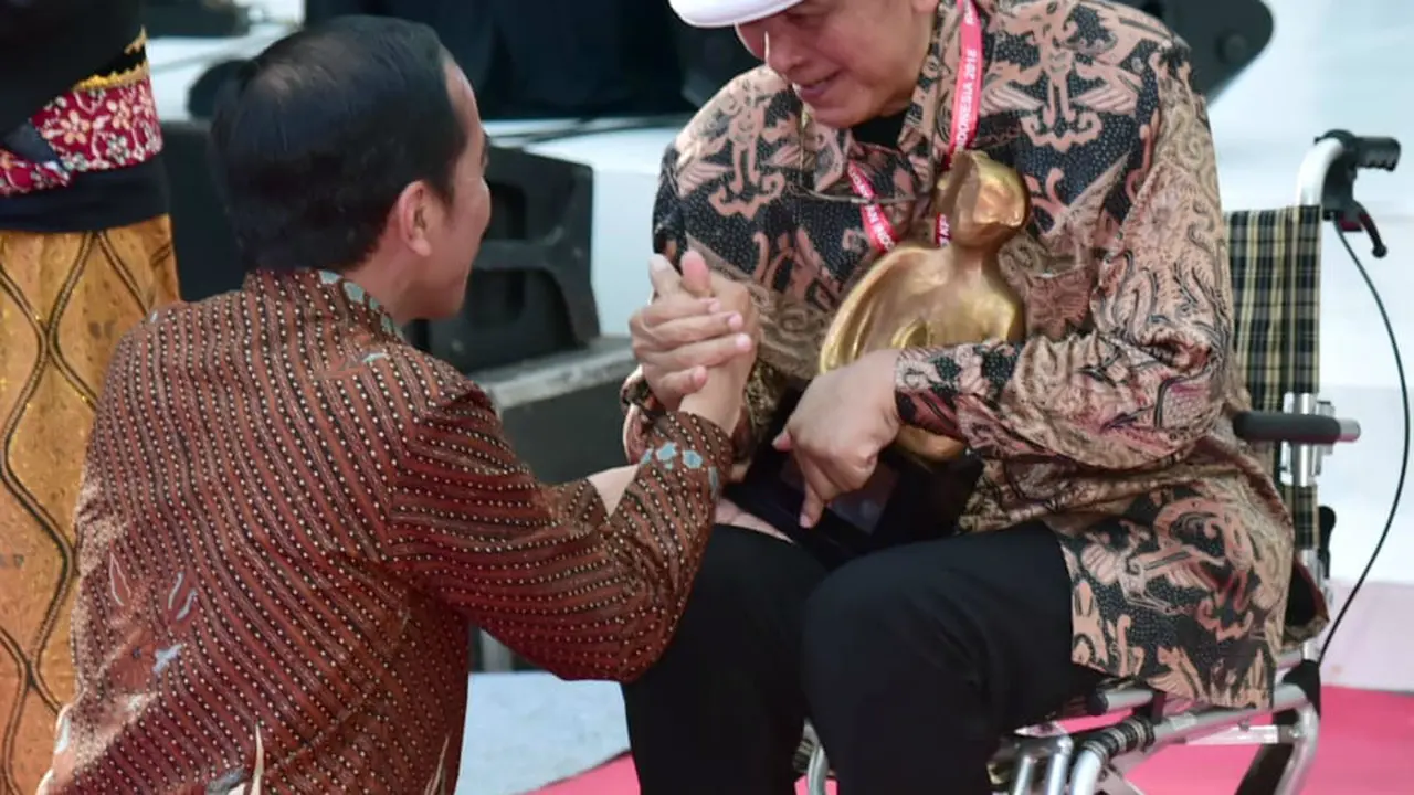 Presiden Jokowi berjongkok saat memberikan penghargaan kepada sastrawan Putu Wijaya di Kantor Kemendikbud, Jakarta, Minggu (9/12/2018). (Foto: Muchlis Jr - Biro Pers Sekretariat Presiden)