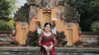 Kebaya Bali yang cantik ini dipadukan dengan kain Endek berwarna senada dan kain yang menjadi ikan pinggang berwarna merah marun.(instagram/doleytobing)