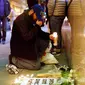 Seorang pria meletakkan lilin di depan Kedutaan Prancis di San Francisco, California sebagai penghormatan kepada korban serangan Paris. (Reuters)