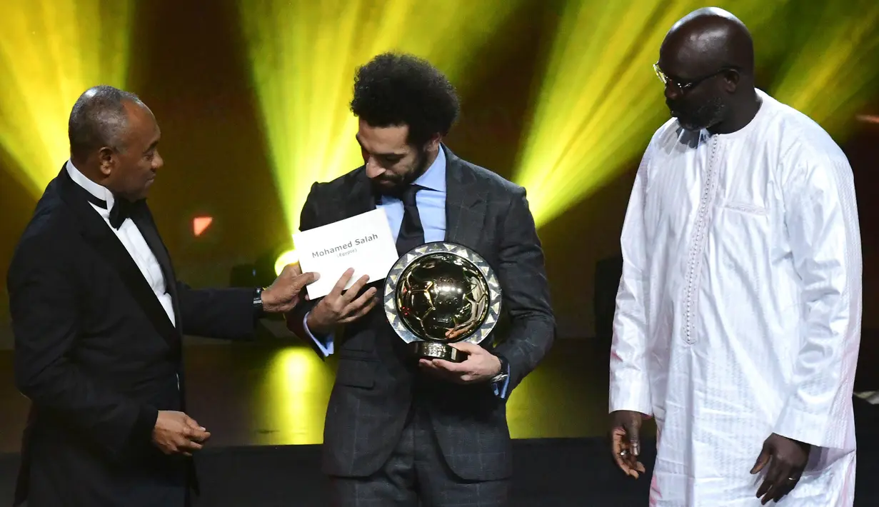 Presiden Konfederasi Sepak Bola Afrika (CAF) Ahmad Ahmad memberikan penghargaan Pemain Terbaik Afrika 2018 kepada bintang Liverpool, Mohamed Salah dalam malam penghargaan di Dakar, Senegal, Selasa (8/1). (SEYLLOU/AFP)