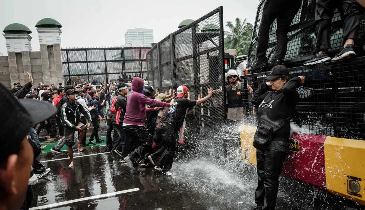 Sejumlah massa sempat bertindak anarkis dengan melemparkan batu ke arah kantor satuan pengamanan gedung DPR. Ada pula aksi pembakaran sepeda motor. (YASUYOSHI CHIBA/AFP)