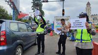 Petugas kepolisian mengimbau pengendara untuk mengurungkan perjalanannya ke Puncak, Bogor mengingat lalu lintas di kawasan itu sangat padat, Senin (24/4/2023). (Liputan6.com/ Achmad Sudarno)
