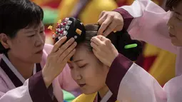 Seorang pelajar mempersiapkan diri sebelum mengikuti upacara Coming of Age Day di Namsan Hanok Village, Seoul, Senin (15/5). Upacara Hari Kedewasaan adalah hari libur resmi untuk menghormati siapa saja yang baru menginjak usia 20 tahun. (Ed JONES/AFP)
