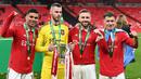 Kiper Manchester United, David de Gea (kedua kiri) bersama rekannya berpose dengan trofi Carabao Cup setelah memenangkan laga final melawan Newcastle United di Stadion Wembley Stadium, London, 26 Februari 2023. Ini merupakan trofi kedua Carabao Cup yang pernah dipersembahkan De Gea saat berseragam MU. Sebelumnya, Ia pernah merebut trofi tersebut pada musim 2016/2017. (AFP/Glyn Kirk)