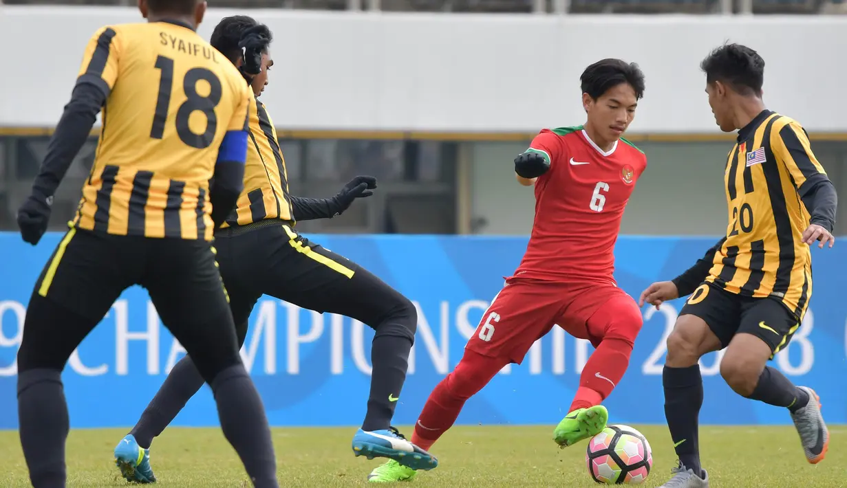 Gelandang Timnas Indonesia U-19, Muhammad Iqbal, berusaha melewati pemain Malaysia U-19 pada laga Kualifikasi Piala Asia U-19 2018 di Stadion Public, Paju, Senin (6/11/2017). Indonesia kalah 1-4 dari Malaysia. (AFP/Kim Doo-Ho)