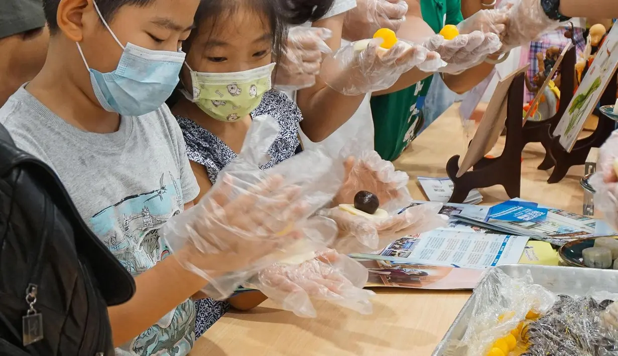 Para turis mencoba membuat kue bulan di kawasan jalan komersial di Guangzhou, Provinsi Guangdong, China selatan, pada 1 Oktober 2020. Masyarakat di seluruh China menikmati beragam makanan lezat selama libur Hari Nasional dan Festival Pertengahan Musim Gugur. (Xinhua/Liu Dawei)