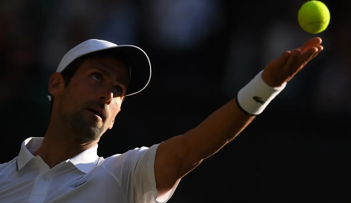 Petenis Serbia, Novak Djokovic bersiap melakukan servis ke petenis AS, Denis Kudla pada babak kedua Wimbledon di All England Lawn Tennis Club, London, Kamis (4/7/2019) dini hari. Petenis nomor satu dunia itu menang straight set 6-3, 6-2, 6-2 atas Denis Kudla. (Ben STANSALL/AFP)