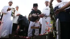  Aktor Iko Uwais menaburkan bunga di pemakaman ayahnya Musthafa Kamaluddin di TPU Prumpung, Jakarta, Rabu (8/3). Ayah Iko Uwais wafat pada  Rabu (8/3/2017) pagi di RSCM. (Liputan6.com/Herman Zakharia)