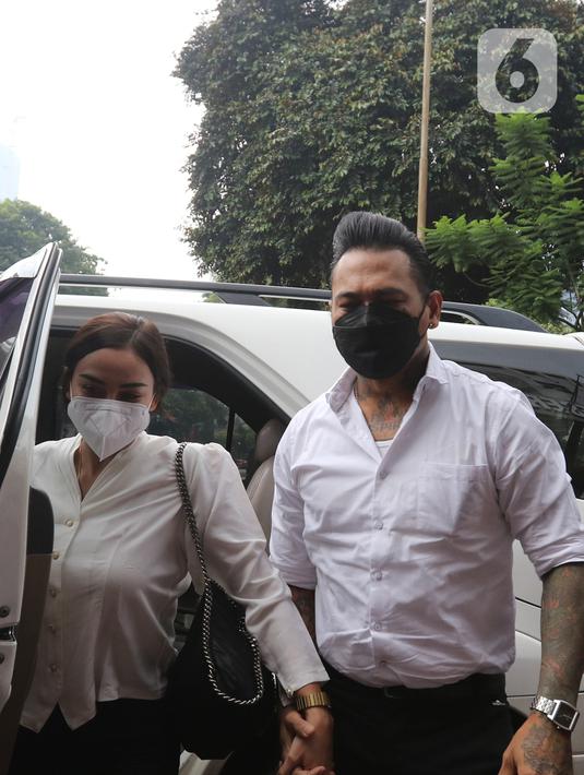 Musikus I Gede Ary Astina alias Jerinx didampingi istrinya, Nora Alexandra, tiba di Polda Metro Jaya, Jakarta, Sabtu (14/08/2021). Kedatangan Jerinx untuk menghadiri proses mediasi dengan pegiat media sosial Adam Deni terkait kasus dugaan pengancaman yang menjeratnya. (Liputan6.com/Herman Zakharia)