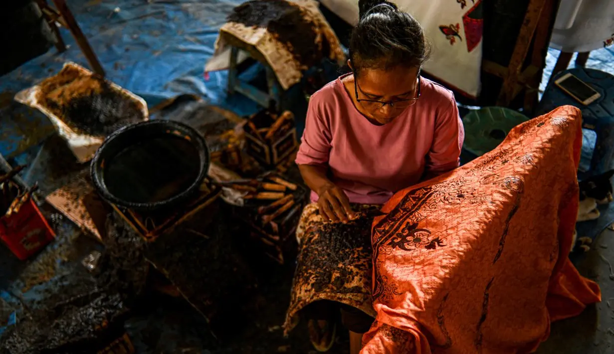 Seorang pekerja membuat desain batik di sebuah bengkel di Banda Aceh, Aceh, Rabu (13/10/2021). Untuk warna yang dominan dipakai dalam batik Aceh adalah warna cerah seperti merah muda, merah, kuning, hijau dan lainnya. (Chaideer MAHYUDDIN/AFP)