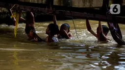 Sejumlah anak bermain dan berenang di aliran Kalimalang, Jakarta, Sabtu (15/2/2020). Cuaca yang tidak menentu membuat aliran air terkadang menjadi deras sehingga akan membahayakan keselamatan anak-anak saat bermain dan berenang. (merdeka.com/Imam Buhori)