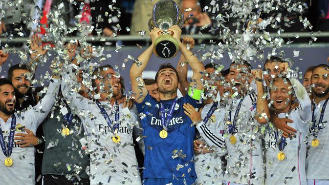 Kiper Real Madrid Iker Casillas mengangkat trofi Piala Super UEFA setelah mengalahkan Sevilla di Stadion Cardiff City di Cardiff, Wales selatan pada 12 Agustus 2014. (AFP/GLYN KIRK)