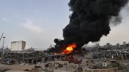 Petugas pemadam kebakaran berupaya memadamkan api yang membakar gudang-gudang di Pelabuhan Beirut, Lebanon, Kamis (10/9/2020). Tentara Lebanon mengatakan kobaran api berkobar dari gudang penyimpanan minyak dan ban di area Bebas Pajak pelabuhan. (AP Photo/Hussein Malla)