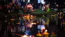 Orang-orang Thailand menghayutkan 'krathong' untuk merayakan festival Loy Krathong di sebuah danau di Bangkok, Kamis (22/11). Festival ini biasanya berlangsung pada akhir musim hujan, ketika bulan purnama menyala di langit pada November. (Jewel SAMAD/AFP)