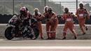 Sejumlah petugas lintasan tengah membantu pembalap Aprilia, Aleix Espargaro setelah terjatuh dari motornya  saat sesi latihan bebas MotoGP Indonesia 2023 di Sirkuit Mandalika, Lombok, Nusa Tenggara Barat, Jumat (13/10/2023). (AFP/Sonny Tumbaleka)