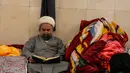 Seorang Muslim Syiah membaca Al-Quran saat melaksanakan Itikaf di Masjid Kufa, selatan Baghdad, Irak, pada 12 Maret 2026. (Qassem al-KAABI/AFP)