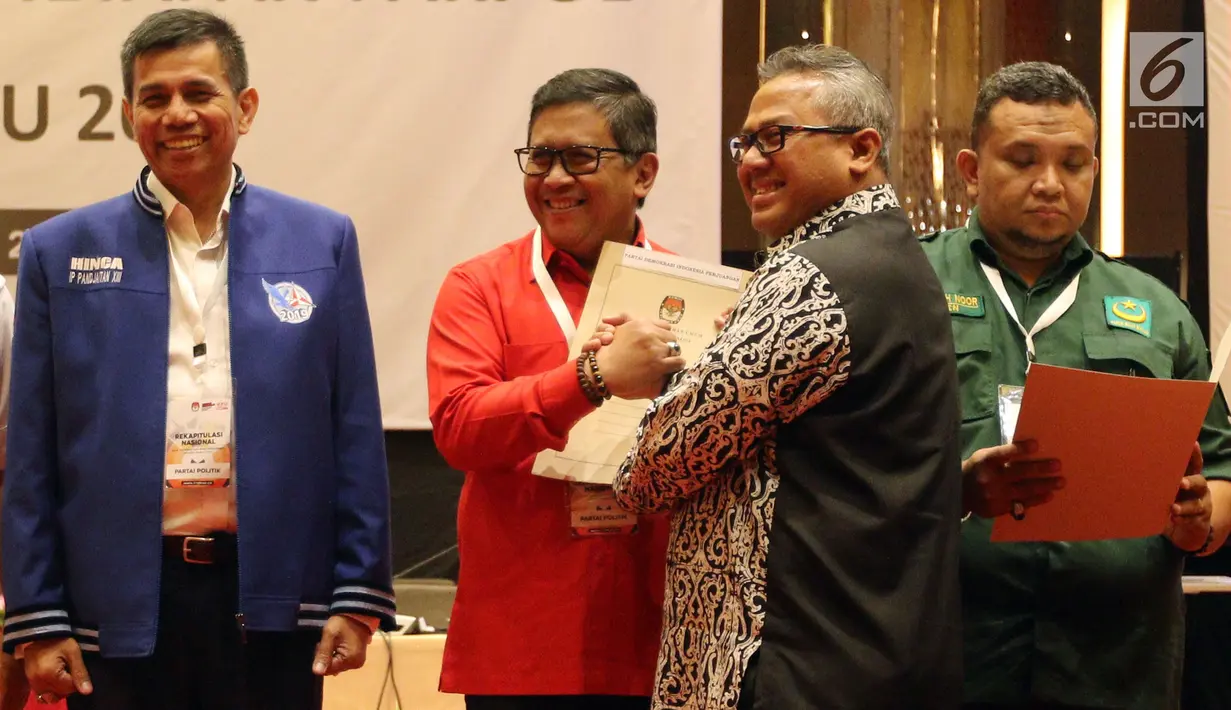 Sekjen PDIP Hasto Kristiyanto menerima berita acara hasil rekapitulasi dari Ketua KPU Arief Budiman saat Rekapitulasi Nasional Hasil Verifikasi Peserta Pemilu 2019, Jakarta (17/2). (Liputan6.com/JohanTallo)