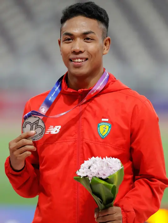 Sprinter Indonesia, Lalu Muhammad Zohri berpose seusai menerima medali perak nomor 100 meter pada Kejuaraan Atletik Asia 2019 di Doha, Qatar, Senin (22/4). Lalu Muhammad Zohri tampil sebagai yang tercepat kedua di semifinal dengan membukukan catatan waktu 10,13 detik. (AP/Vincent Thian)