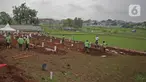 Petugas dengan APD melakukan proses pemakaman dengan protokol Covid-19 di TPU Bambu apus, Jakarta Timur, Minggu (24/1/2021). Empat hari dibuka, 126 jenazah telah dikebumikan dengan protap Covid-19 di TPU Bambu Apus, Cipayung, Jakarta Timur. (Liputan6.com/Herman Zakharia)