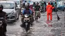 Sejumlah kendaraan melintasi genangan air usai hujan deras dikawasan Tugu Tani, Jakarta, Kamis (12/10). Agar tidak terjadi genangan kembali petugas dari Dinas Kebersihan membuang aliran air hujan kedalam selokan. (Liputan6.com/Faizal Fanani)