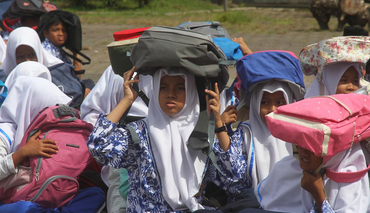 Para murid menggunakan tas untuk pelindung dalam latihan tsunami di Meulaboh (5/9). Sebanyak 24 negara yang berbatasan dengan Samudra Hindia, dari Australia hingga Yaman, mengambil bagian dalam latihan kesiapsiagaan bencana dua tahunan. (AFP Photo/Januar)