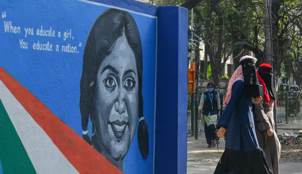 Siswa sekolah untuk wanita memasuki gedung lembaga pendidikan di Bangalore (16/2/2022). Sekolah dibuka kembali di India selatan di bawah pengamanan ketat pihak berwenang melarang pertemuan publik menyusul protes atas gadis-gadis Muslim yang mengenakan jilbab di ruang kelas. (AFP/Manjunath Kiran)