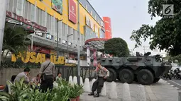 Polisi berjaga dekat Panser Anoa yang terparkir di pusat perbelanjaan kawasan Glodok, Jakarta, Kamis (27/6/2019). TNI dan Polri mengamankan sejumlah pusat perbelanjaan di Jakarta guna mengantisipasi hal tidak diinginkan saat pembacaan putusan sidang sengketa Pilpres 2019. (merdeka.com/Iqbal Nugroho)