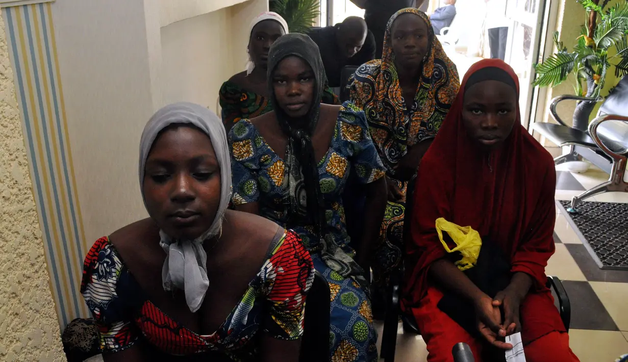 Gadis-gadis sekolah Chibok yang baru saja dibebaskan dari penahanan Boko Haram menunggu untuk bertemu Presiden Muhammadu Buhari di Abuja, Nigeria (7/5). Sebanyak 82 dari 276 siswa perempuan Chibok berhasil dibebaskan. (AP Photo/Olamikan Gbemiga)