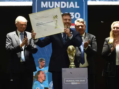 Presiden Conmebol, Alejandro Dominguez dari Paraguay memegang sertifikat yang mengesahkan Argentina, Paraguay, dan Uruguay sebagai tuan rumah tiga pertandingan pembuka Piala Dunia 2030 saat Kongres Luar Biasa FIFA yang digelar secara virtual di Luque, Paraguay, pada 11 Desember 2024. (DANIEL DUARTE/AFP)