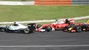 Pebalap Ferrari, Sebastian Vettel, bersenggolan dengan pebalap Mercedes, Nico Rosberg (kiri), saat balapan F1 GP Malaysia di Sirkuit Sepang, Minggu (2/10/2016). (AFP/Mohd Rasfan)