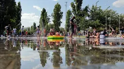 Mulai akhir pekan ini, Eropa bagian selatan akan kembali menghadapi suhu ekstrem yang melebihi 40°C. Tampak dalam foto, orang-orang mendinginkan diri di bawah air mancur di area rekreasi Madrid Rio selama gelombang panas pertama musim panas di Madrid, pada 28 Juni 2025. (Thomas COEX/AFP)