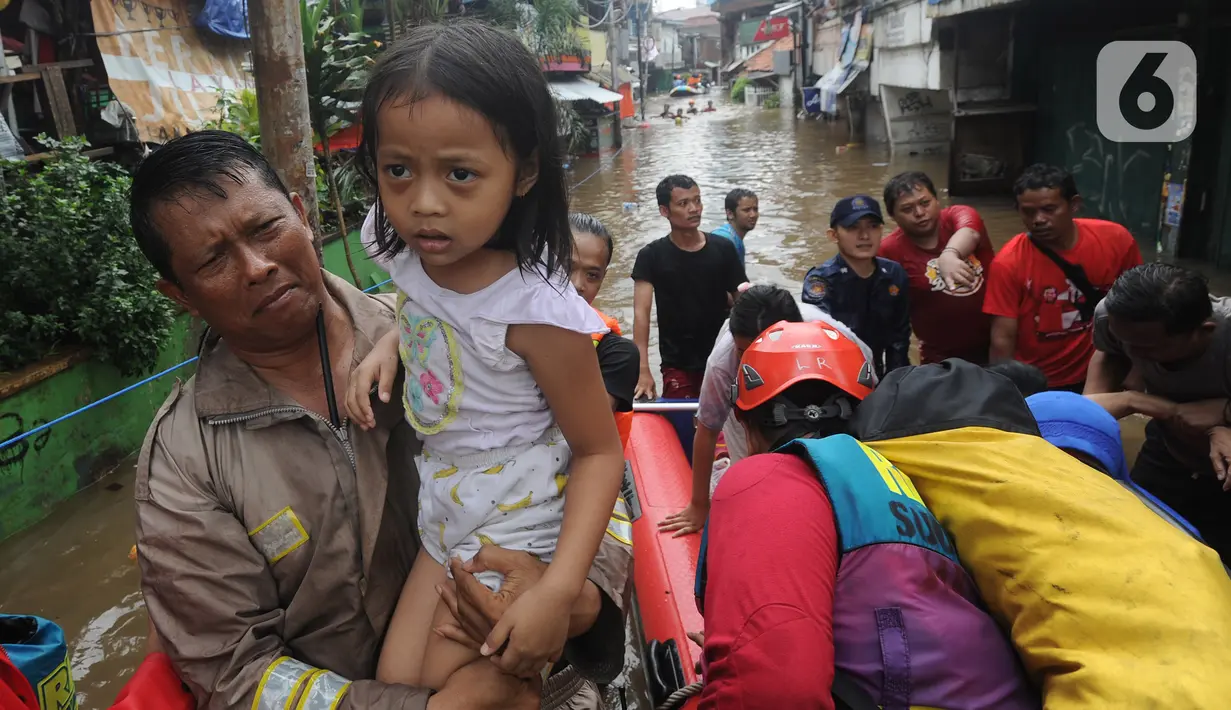 Petugas mengevakuasi anak-anak korban banjir di kawasan Karet Pasar Baru Barat, Jakarta, Selasa (25/2/2020). Banjir yang terjadi sejak subuh akibat luapan Kanal Banjir Barat tersebut merendam ratusan rumah hingga setinggi dua meter. (merdeka.com/Arie Basuki)