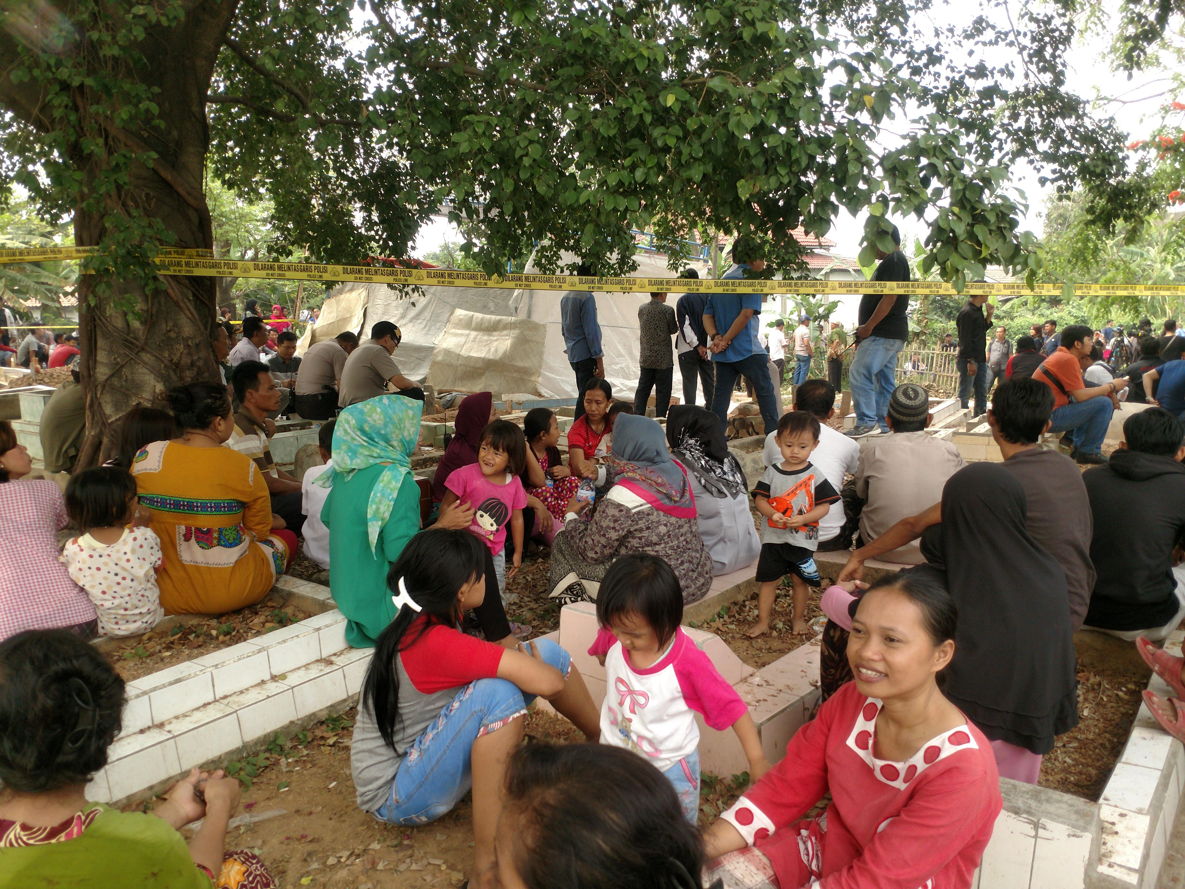 Warga mulai berkerumun di TPU Kedondong, BTN Buni Asih, Kampung Kongsi, Cikarang Utara, Kabupaten Bekasi, untuk menyaksikan proses pembongkaran makam Joya, korban pembakaran hidup-hidup di Bekasi (Liputan6.com/Fernando Purba)