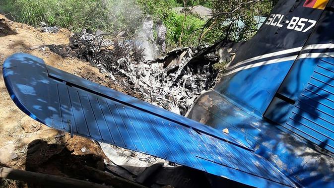 Petugas penyelamat memeriksa puing-puing  pesawat milik Angkatan Udara Sri Lanka yang jatuh di daerah pegunungan penghasil teh di Haputale, Jumat (3/1/2020). Hingga kini masih dilakukan investigasi terkait penyebab kecelakaan. (Photo by STR / AFP)