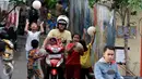 Pengendara motor melintas ketika sejumlah bocah bermain bola di gang kecil kawasan Benhil, Jakarta, Rabu (10/6). Gang kecil itu dimanfaatkan untuk bermain dikarenakan minimnya sarana bermain khususnya lapangan bola di Jakarta. (Liputan6.com/Johan Tallo)