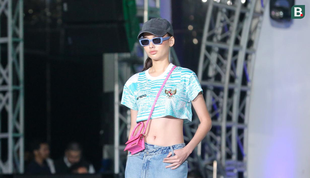 Seorang model wanita memperagakan jersey ketiga Timnas Indonesia produksi jenama dalam negeri Erspo dalam acara launching jersey anyar Timnas Indonesia di Bengkel Space, SCBD, Jakarta, Senin (18/3/2024) petang WIB. (Bola.com/Abdul Aziz)