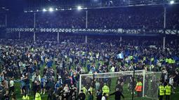 Suporter Everton menyerbu lapangan untuk merayakan akhir pertandingan Liga Inggris antara Everton dan Crystal Palace di Goodison Park di Liverpool, Inggris, 19 Mei 2022. Everton berhasil menang lewat come back dramatis 3-2 dan keluar dari zona degradasi Liga Inggris. (AFP/Oli Scarff)
