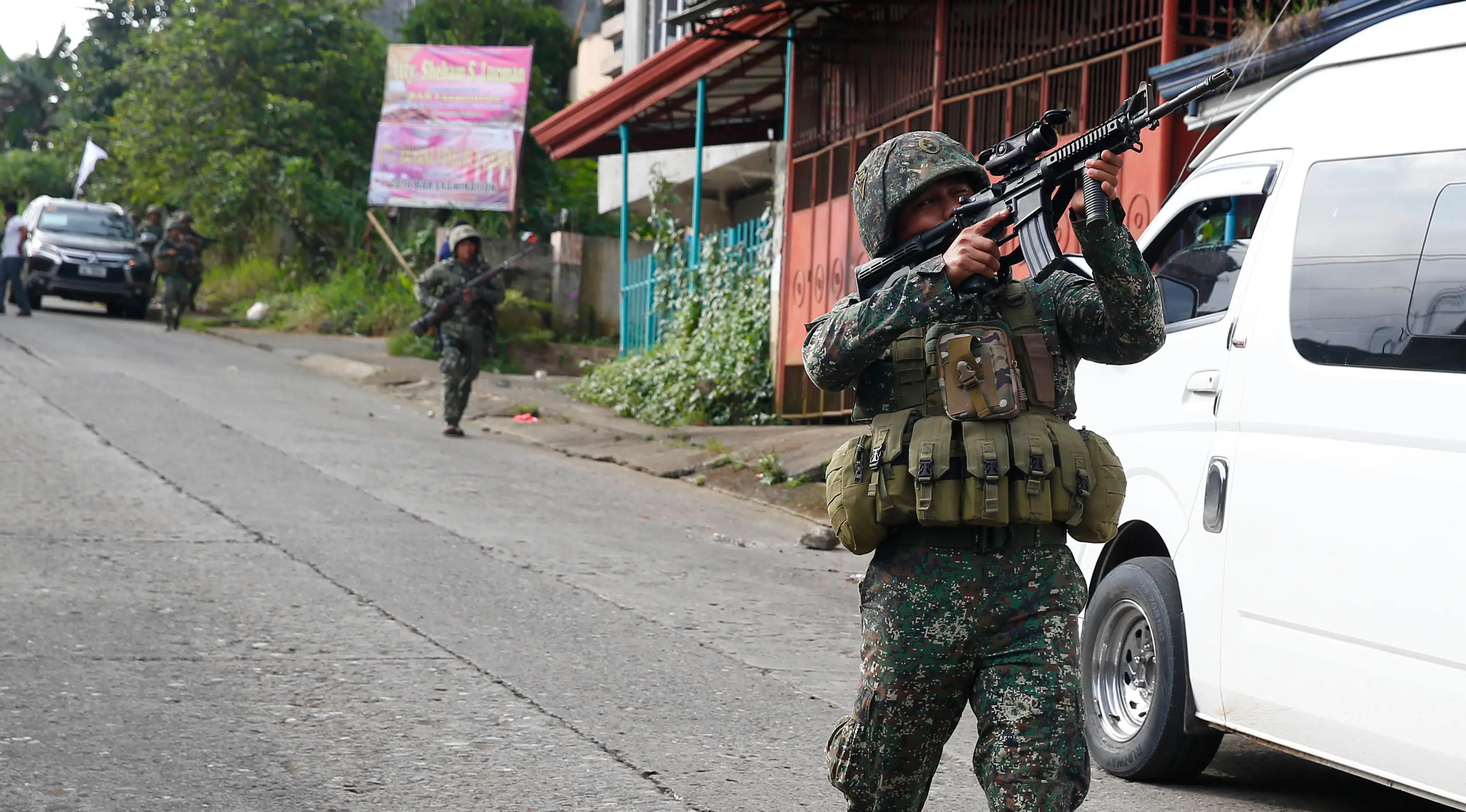 Tentara Filipina mengarahkan senjatanya saat bertempur melawan militan maute di kota Marawi, (28/5). Pasukan Filipina melancarkan serangan udara pada hari Minggu untuk mengusir militan yang terkait dengan kelompok ISIS. (AP Photo/Bullit Marquez)