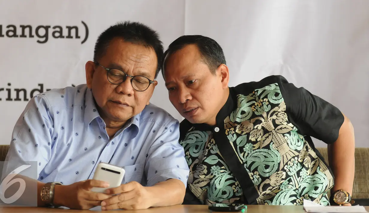 Wakil Ketua DPRD DKI Jakarta, M Taufik (kiri) menunjukkan sesuatu pada peneliti IPI Karyono Wibowo di sela-sela diskusi publik di Jakarta, Kamis (30/6). Diskusi membahas Sulitnya Parpol Mencari Lawan Ahok. (Liputan6.com/Helmi Fithriansyah)