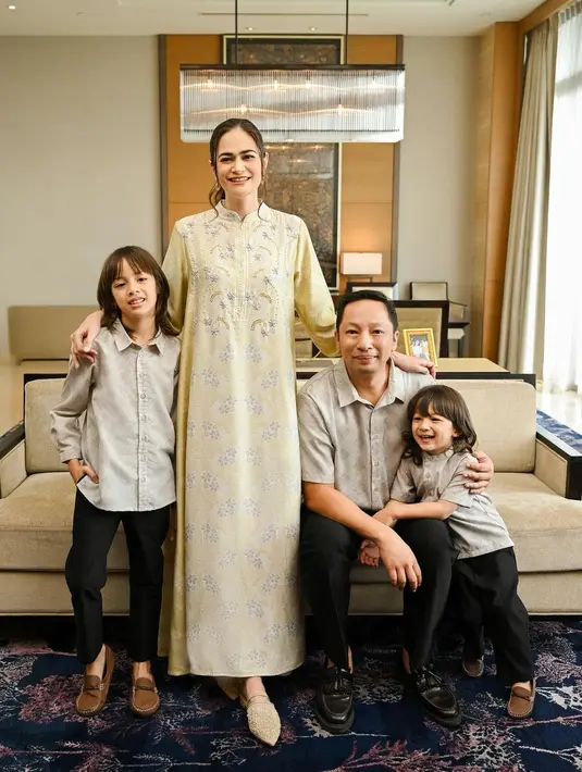 Potret manis keluarga Ringgo Agus dan Sabai Morscheck menghadirkan tampilan baju Lebaran sarimbit. Sabai tampil cantik dengan gamis kuning bercorak floral, dengan detail manis kerah cheongsam. Sedangkan para pria mengenakan kemeja lengan panjang bernuansa abu-abu yang serasi dan celana panjang hitam. [Foto: Instagram/ringgoagus]