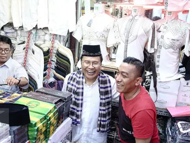 Mantan Menko Maritim,  Rizal Ramli melihat baju-baju saat berkunjung ke Blok A, Pasar Tanah Abang, Jakarta, Sabtu (13/8). Kunjungannya tersebut terkait pencalonannya sebagai cagub pada Pilkada DKI Jakarta 2017.(Liputan6.com/Faizal Fanani)