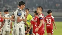 Pemain asing Persis Solo, Sho Yamamoto, yang mendapatkan tugas baru menjadi kapten tim saat berdiskusi dengan bek asing Bali United, Elias Dolah, pada pertandingan lanjutan BRI Liga 1 2024/2025. (Bola.com/Radifa Arsa)