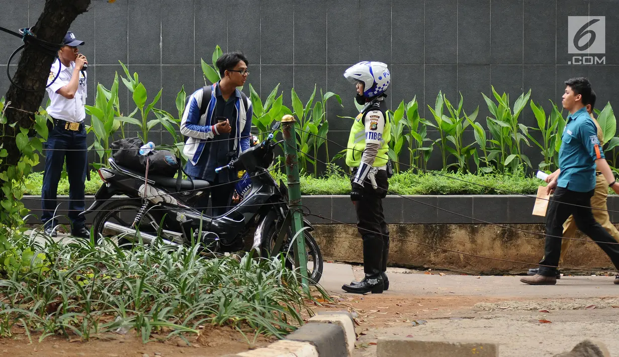 Petugas kepolisian berbincang dengan pengendara motor yang parkir di trotoar Jalan Kebon Sirih, Jakarta, Senin (17/7). Hal ini tindak lanjut maraknya pelanggaran lalu lintas di kawasan pedestrian Jalan Kebon Sirih. (Liputan6.com/Helmi Fithriansyah)