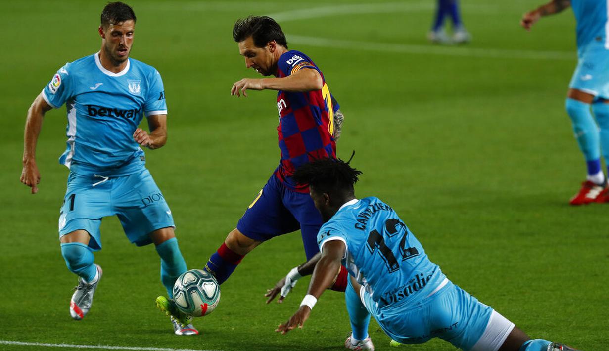 Striker Barcelona, Lionel Messi, berusaha melewati pemain Leganes pada laga La Liga di Stadion Camp Nou, Selasa (16/6/2020). Barcelona menang 2-0 atas Leganes. (AP Photo/Joan Montfort)