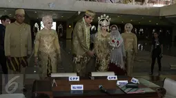 Lucky Hakim dan Tiara Dewi saat memasuki tempat akad nikah di Masjid At Tin, Jakarta, Kamis (19/1). Untuk mempersunting Tiara Dewi, Lucky Hakim menyerahkan 500 gram logam mulia sebagai mahar nikah. (Liputan6.com/Herman Zakharia)