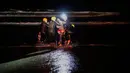 Tim penyelamat menahan seorang imigran Honduras yang berusaha menyeberangi perbatasan AS dari laut di pantai Tijuana, Meksiko, Kamis (29/11). Wali Kota Tijuana meminta bantuan PBB untuk memenuhi kebutuhan hampir 5.000 imigran. (AP Photo/Ramon Espinosa)