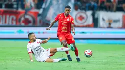 Pemain Persija Jakarta, Alan Cardoso, berusaha melewati pemain Bali United, Mirza Mustafic, dalam lanjutan BRI Super League 2025/2026 di Jakarta International Stadium (JIS), Minggu (14/9/2025) malam WIB. (Bola.com/M Iqbal Ichsan)