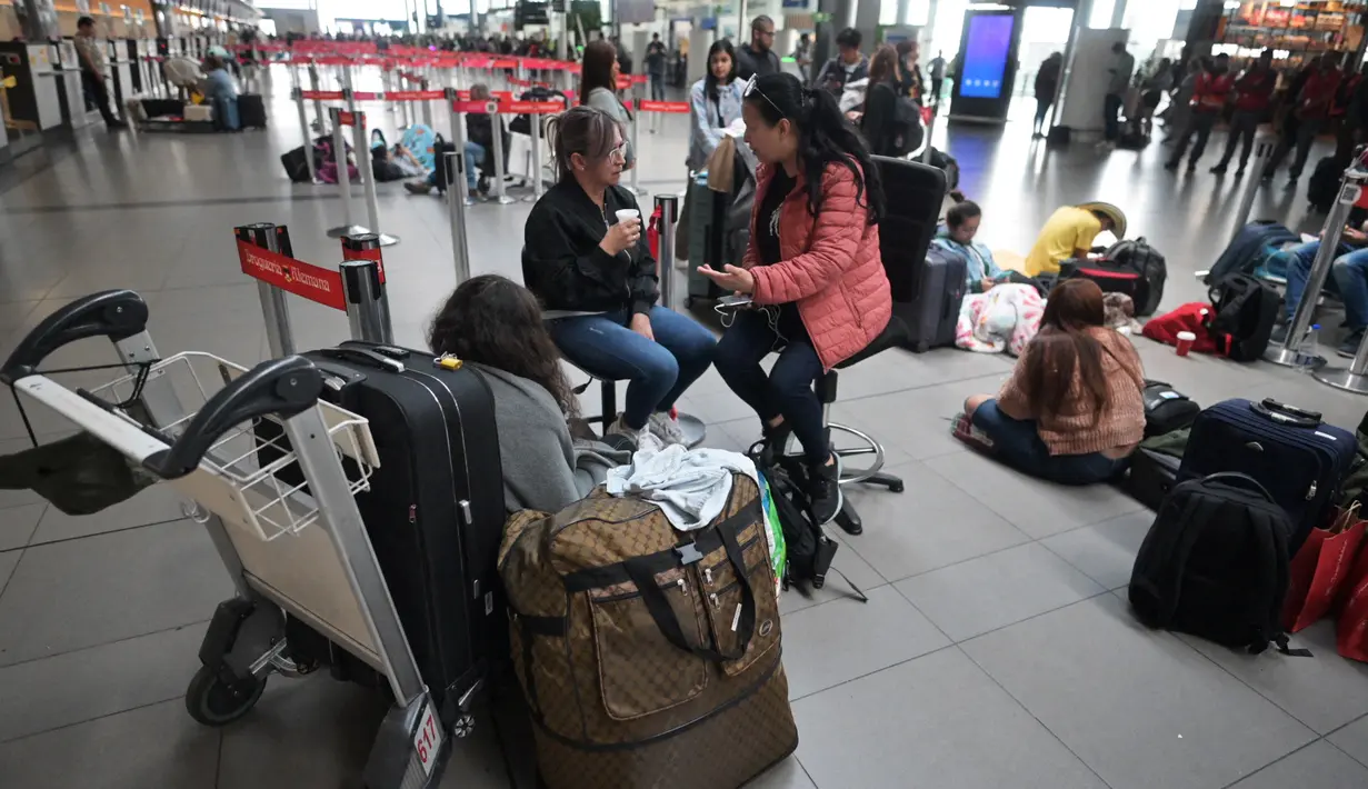 Orang-orang berbaring di lantai setelah penerbangan mereka dengan Maskapai penerbangan bertarif rendah Kolombia Viva Air dibatalkan di bandara internasional El Dorado di Bogota, Selasa (28/2/2023). Lusinan karyawan Viva memprotes di bandara di Bogota pada hari Selasa dengan slogan-slogan seperti "Vida para Viva" (Hidup untuk Viva) dan "Gabung sekarang!" (Juan Barreto / AFP)