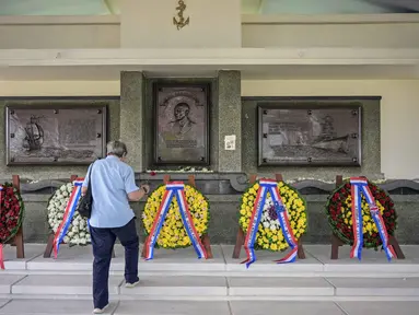 Seorang pria meletakkan bunga di monumen Karel Doorman saat peringatan 84 tahun Pertempuran Laut Jawa di pemakaman perang Belanda Ereveld di Surabaya, Jawa Timur, pada Jumat 27 Februari 2026. 27 Februari 1942, sebuah pertempuran laut terbesar dalam sejarah Perang Dunia II di Pasifik terjadi di wilayah Indonesia. (JUNI KRISWANTO/AFP)